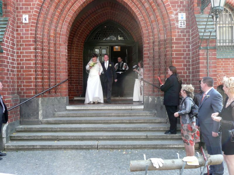 Die Brautpaar verlässt Rathausgebeude in Begleitung von Musik. Es klingt 'Hochzeitsmarsch'